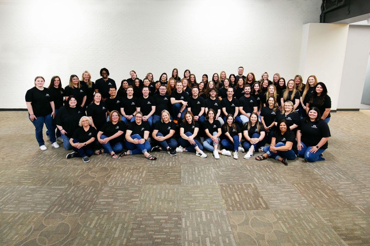 A large group of people are posing for a picture in a room.