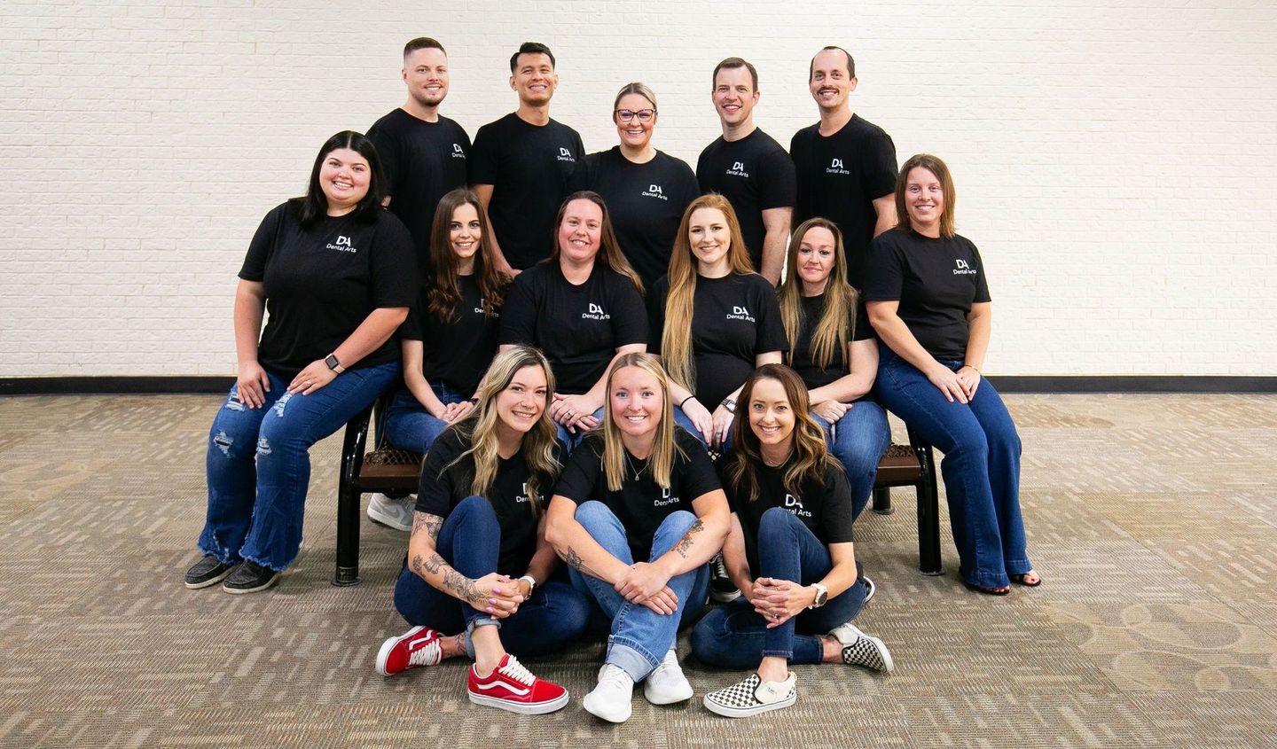 A group of people are posing for a picture while sitting on a bench.