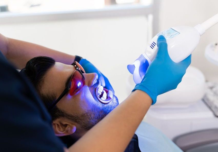 A man is getting his teeth whitened by a dentist.