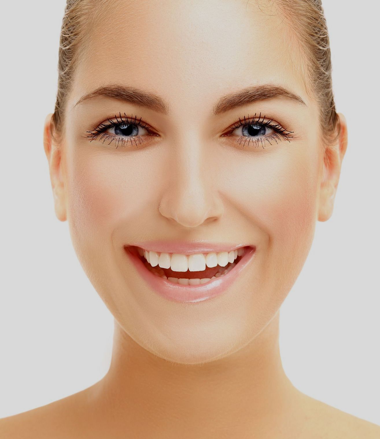 A close up of a woman 's face smiling on a white background