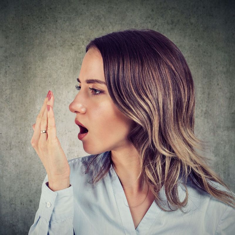 A woman is covering her mouth with her hand.