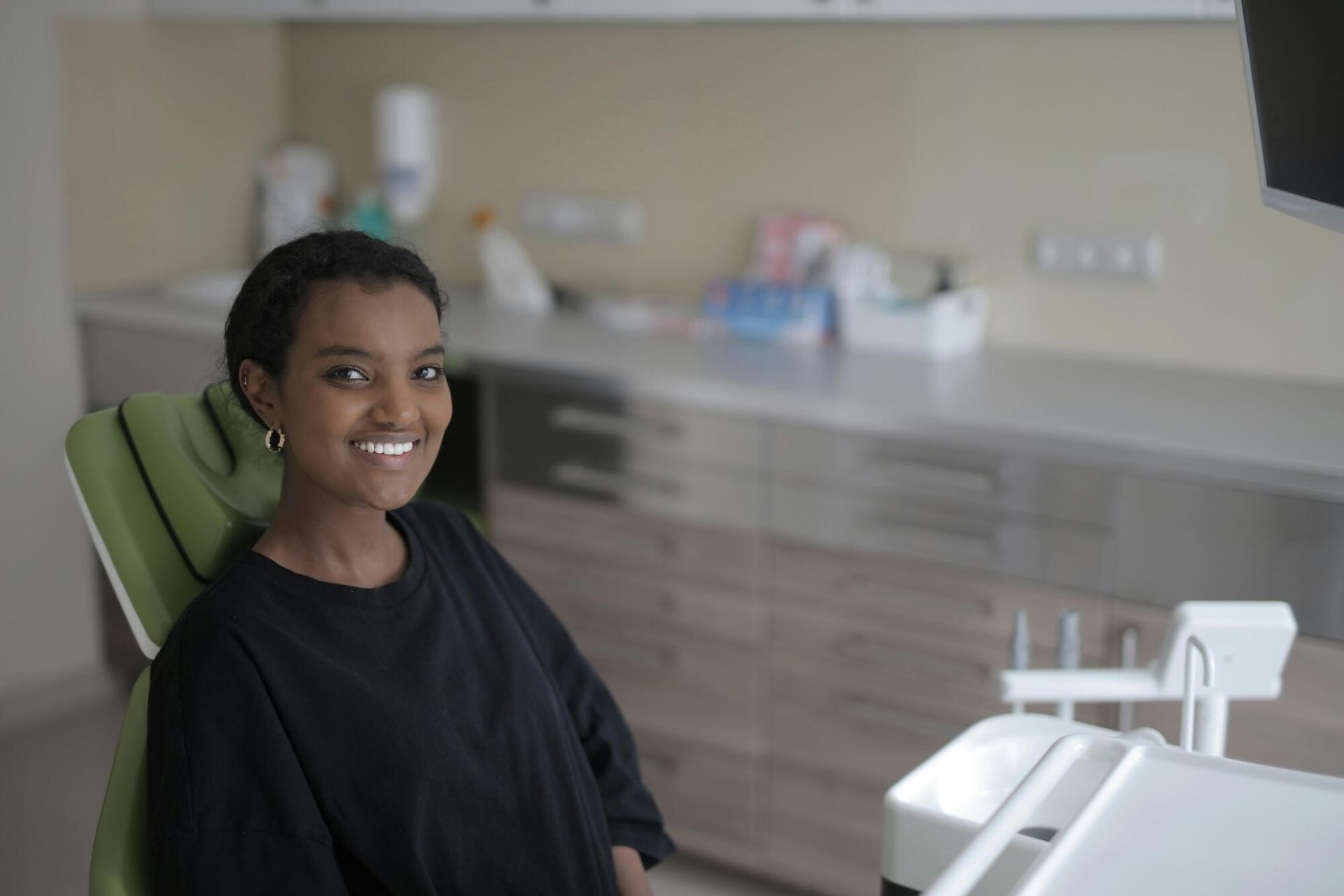 young girl in dentist chair smiling and relaxing.