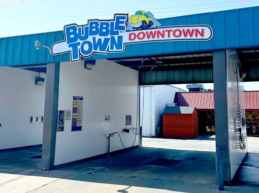 A car wash with a sign that says bubble town downtown