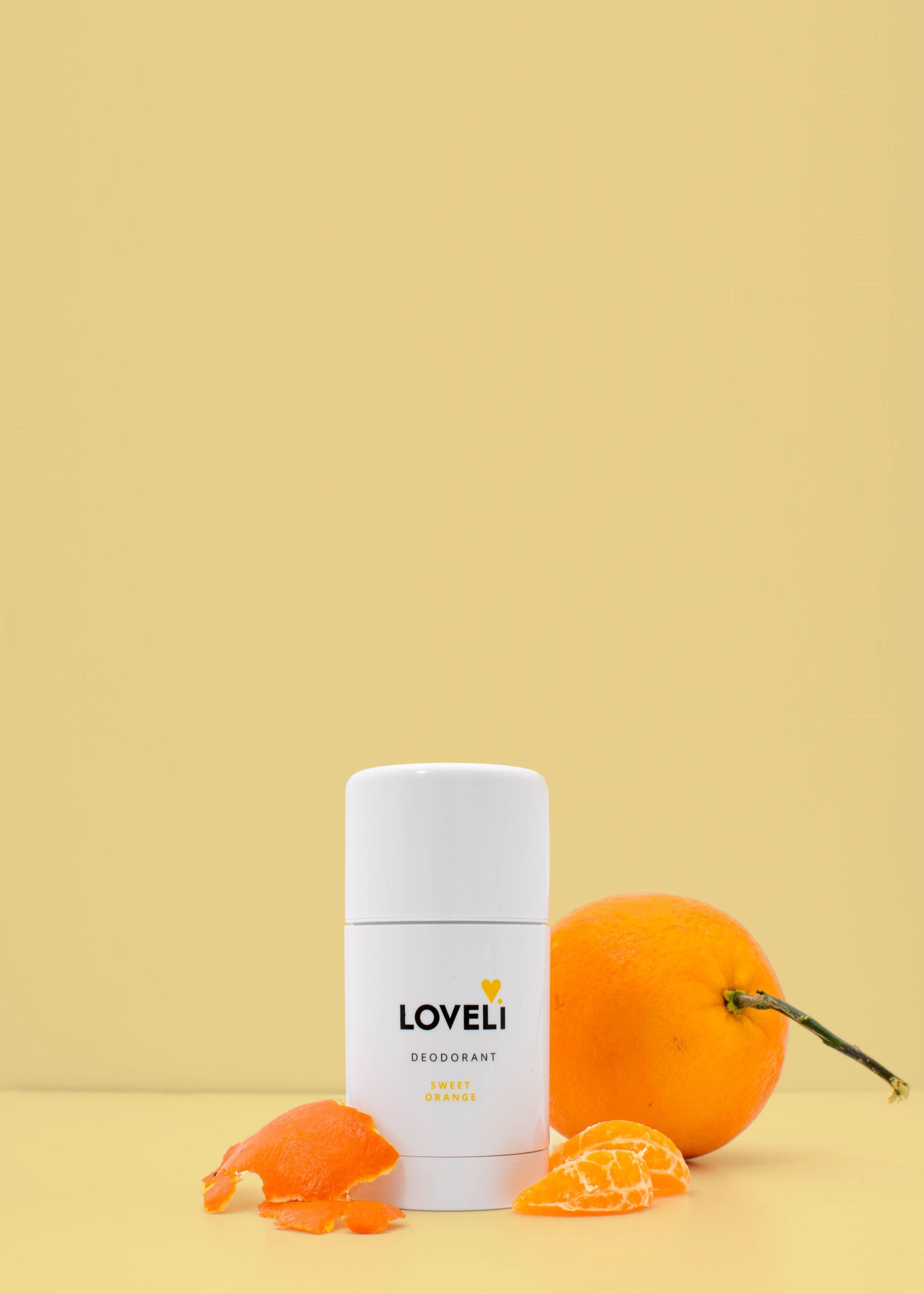 Twee flessen deodorant en een sinaasappelschil op een tafel.