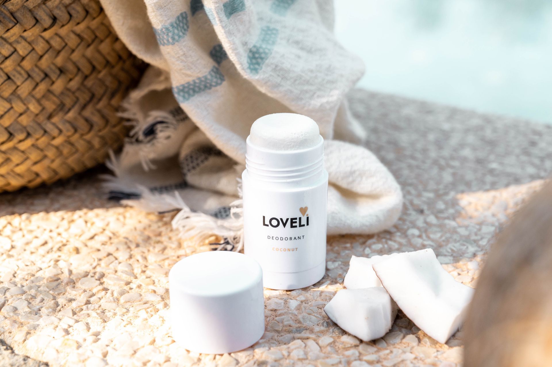 Een fles deodorant staat op een tafel naast een handdoek.