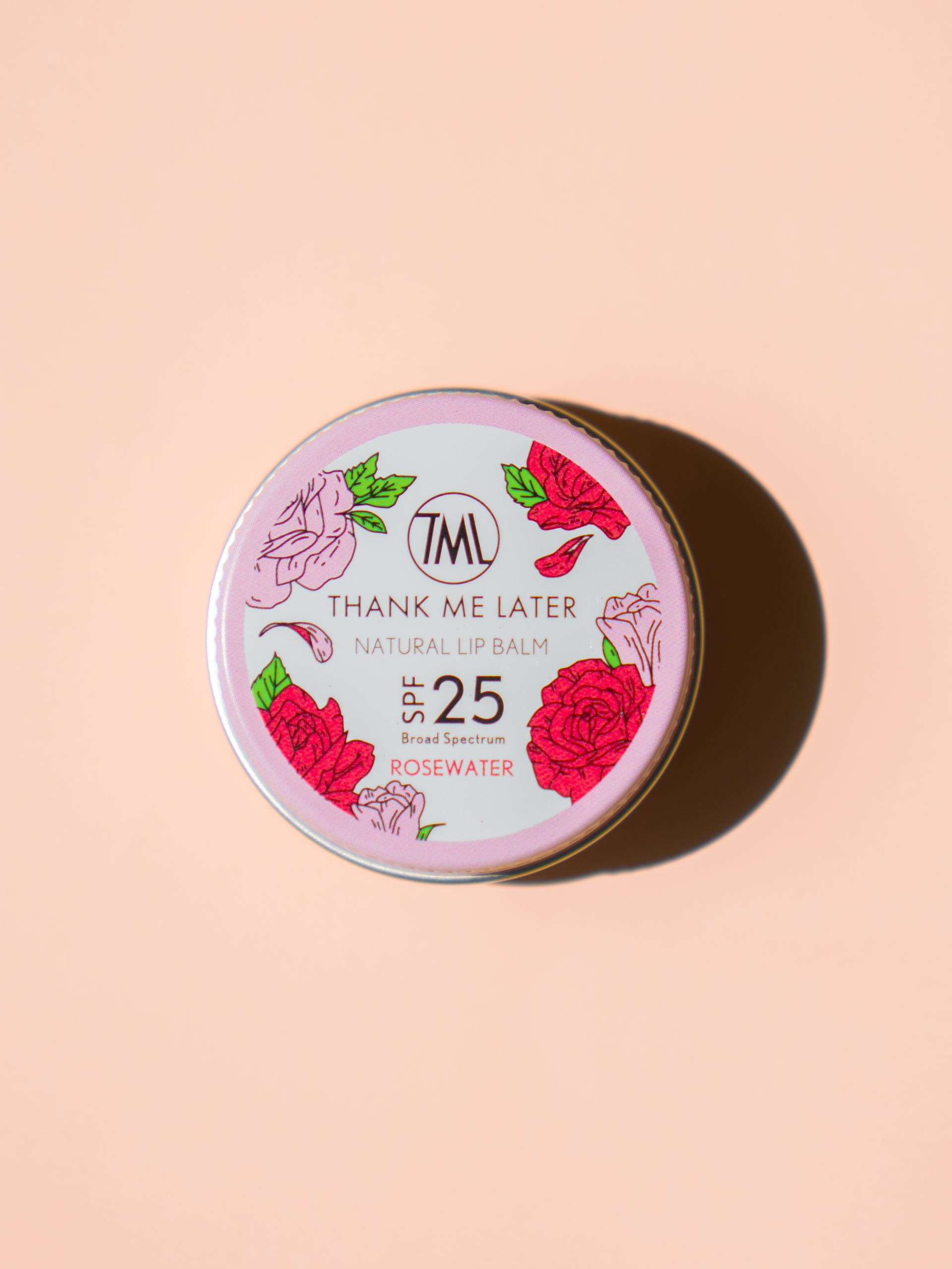 Een roze lippenbalsem ligt op een roze oppervlak.