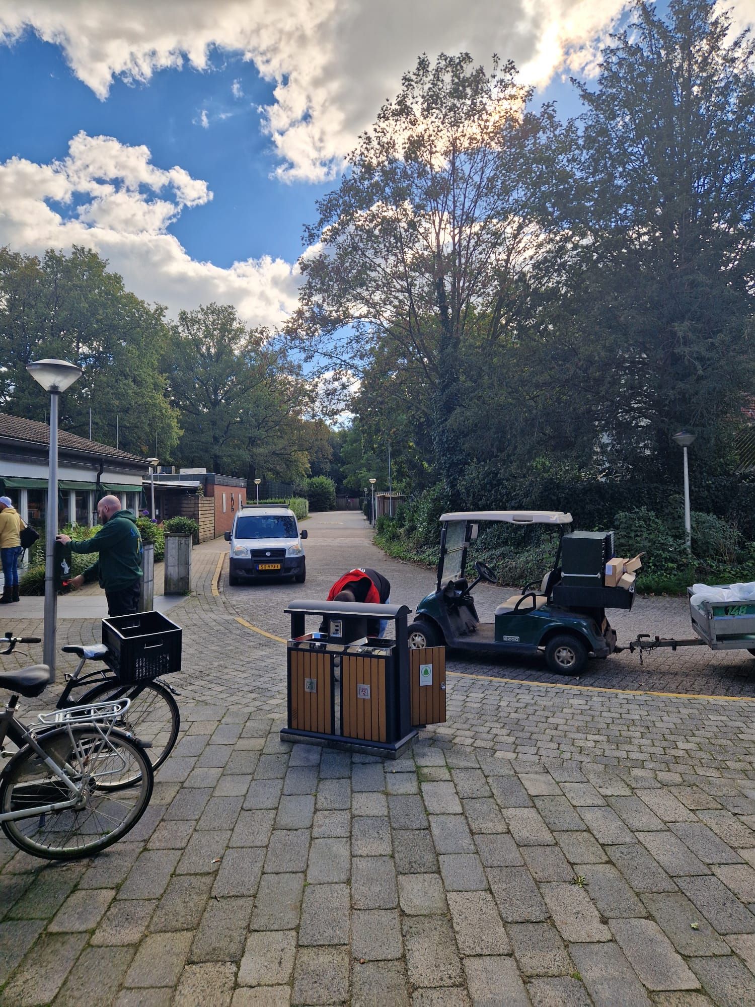 Een fiets staat geparkeerd naast een golfkarretje