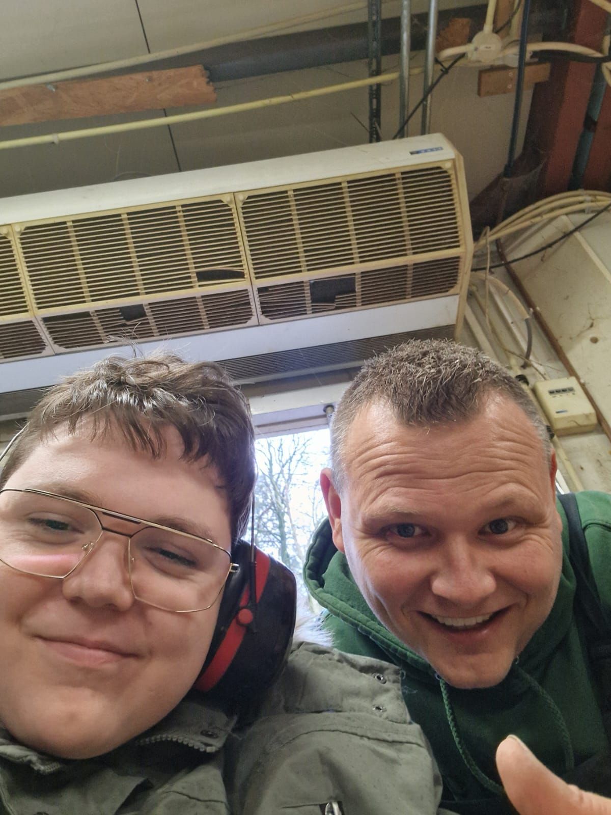 Twee mannen poseren voor een foto voor een airconditioner. Dagbesteding Samen102