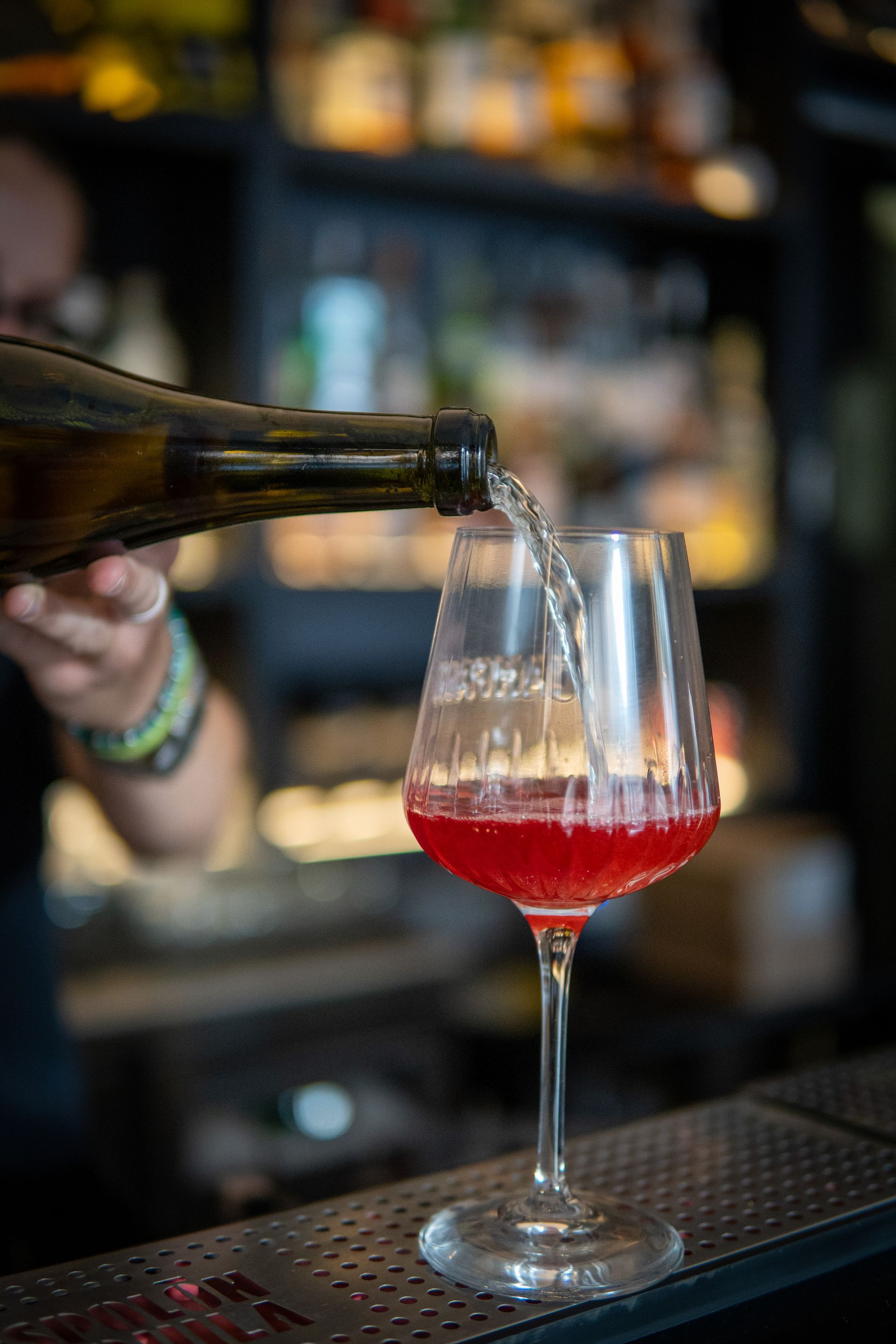 Un tavolo con sopra una bevanda e un bicchiere di vino