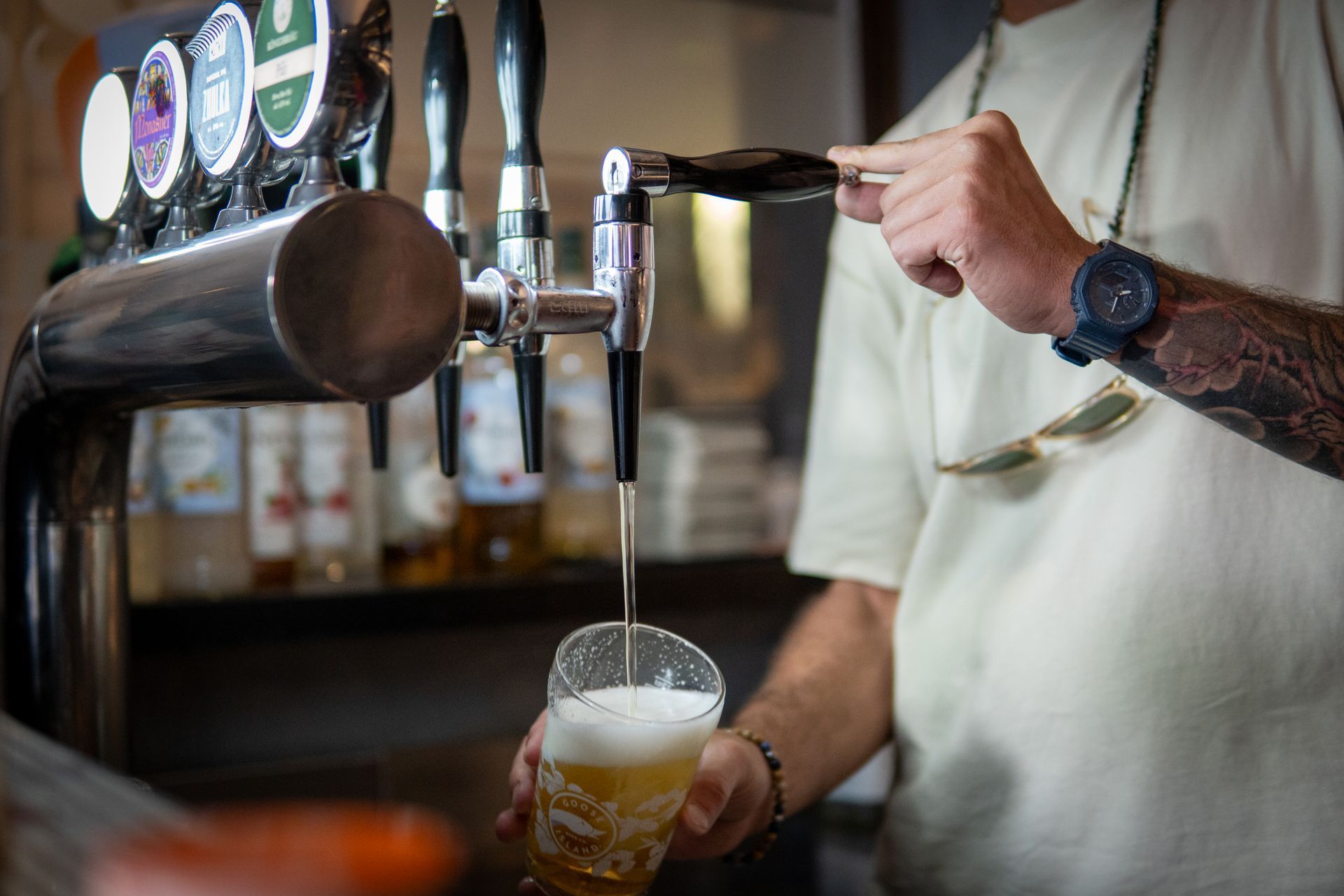 Un ristorante con tavoli e sedie e scaffali pieni di bottiglie di vino.
