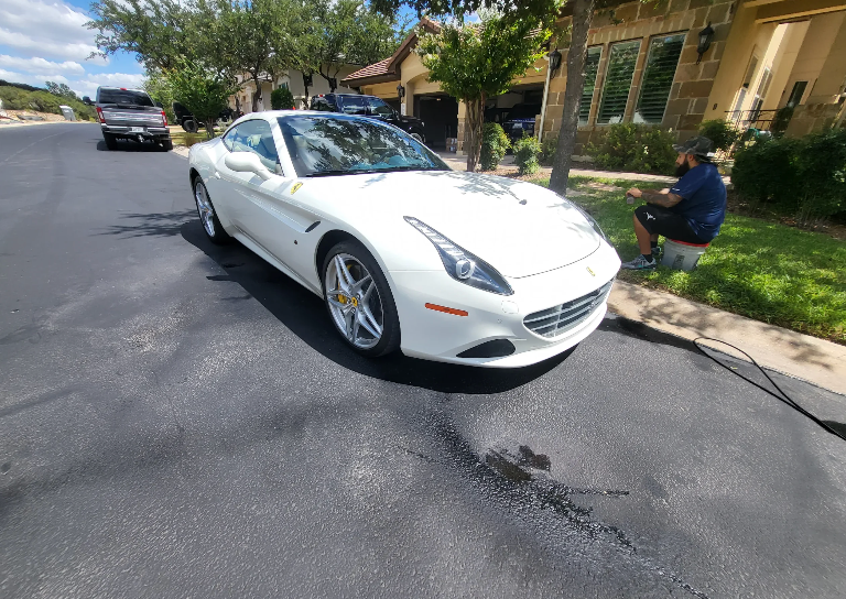 A white sports car is parked on the side of the road.