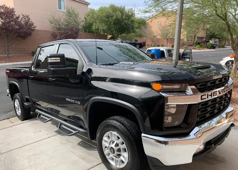 A black chevrolet truck is parked on the side of the road.