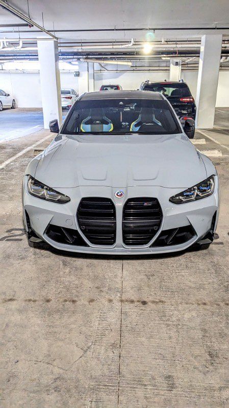 A white bmw m3 is parked in a parking garage.