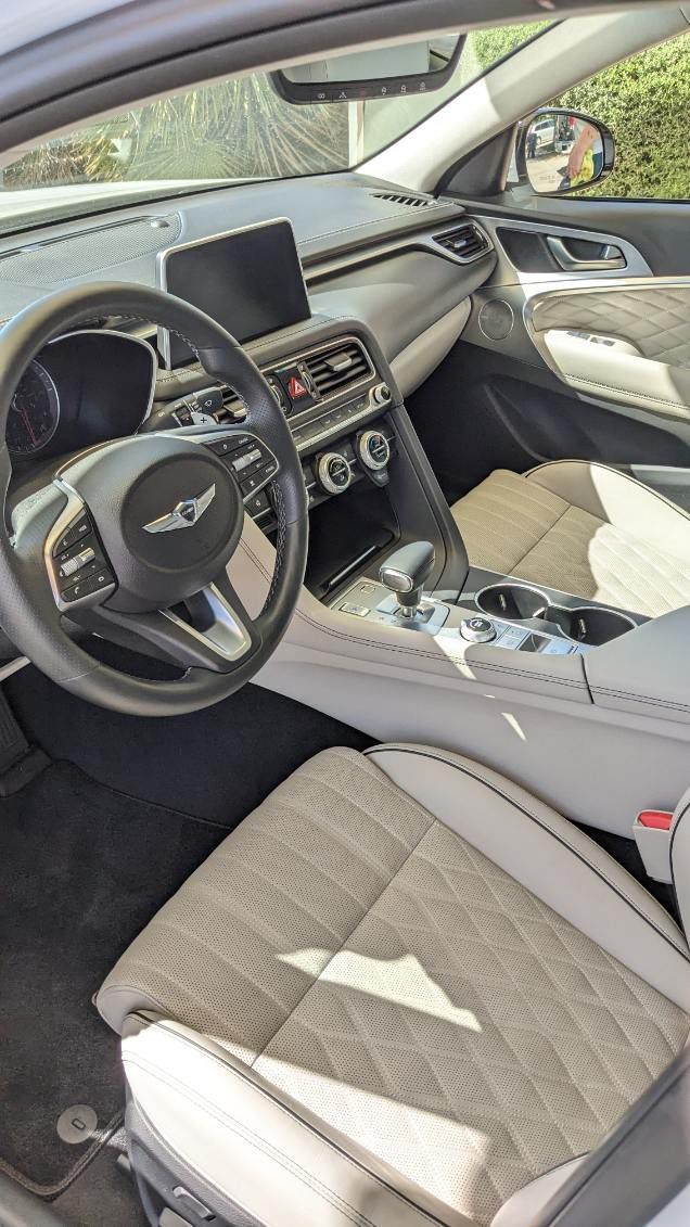 The interior of a car with a steering wheel and seats.