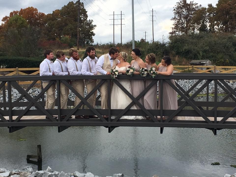 bride and groom with wedding party on bridge