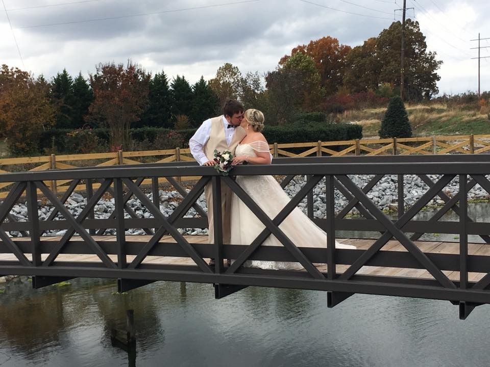 bride and groom kissing on bridge