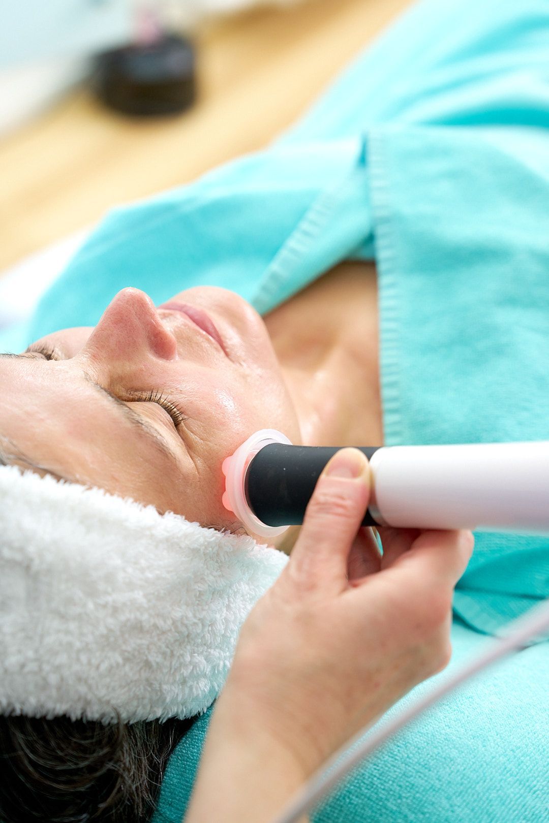 Eine Kosmetikerin wendet die Geneo Gesichtsbehandlung bei einer Kundin an.