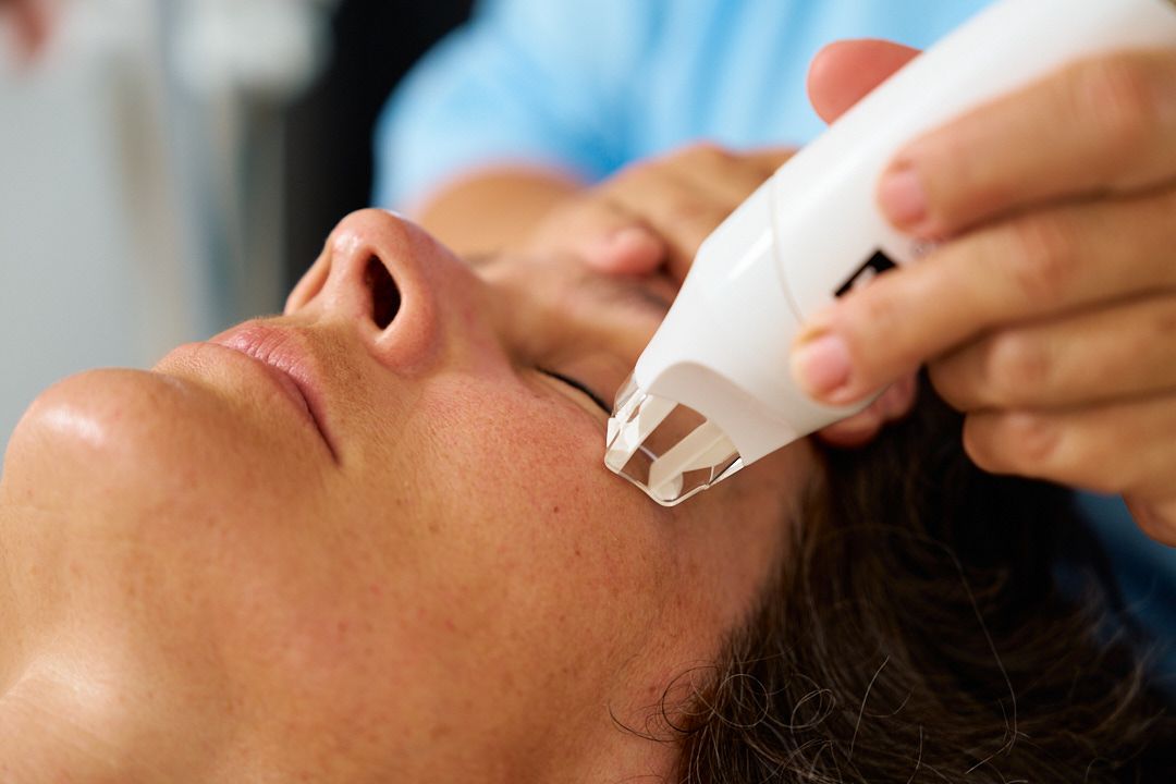 Eine Frau bekommt in einem Schönheitssalon eine Gesichtsbehandlung mit LPG Endermologie