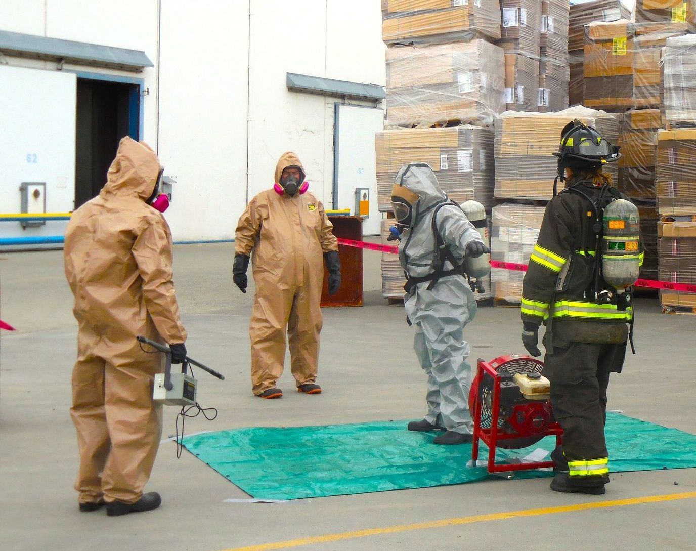 A group of people in protective suits are standing in a parking lot