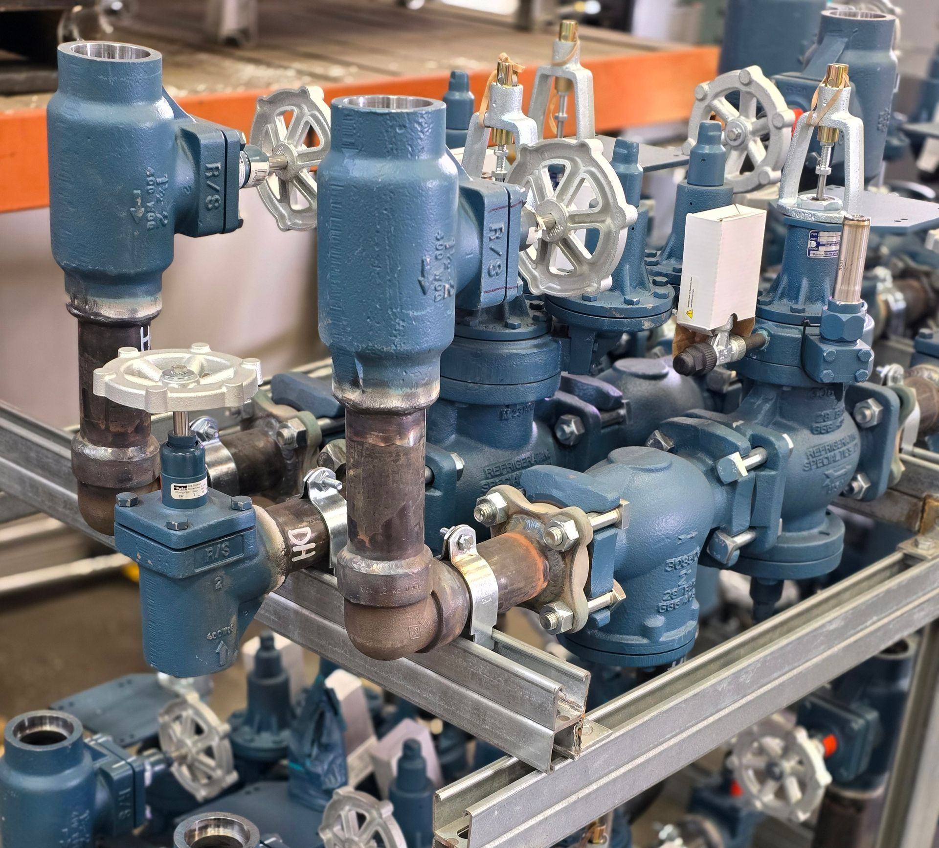 A bunch of blue pipes and valves are sitting on a rack.