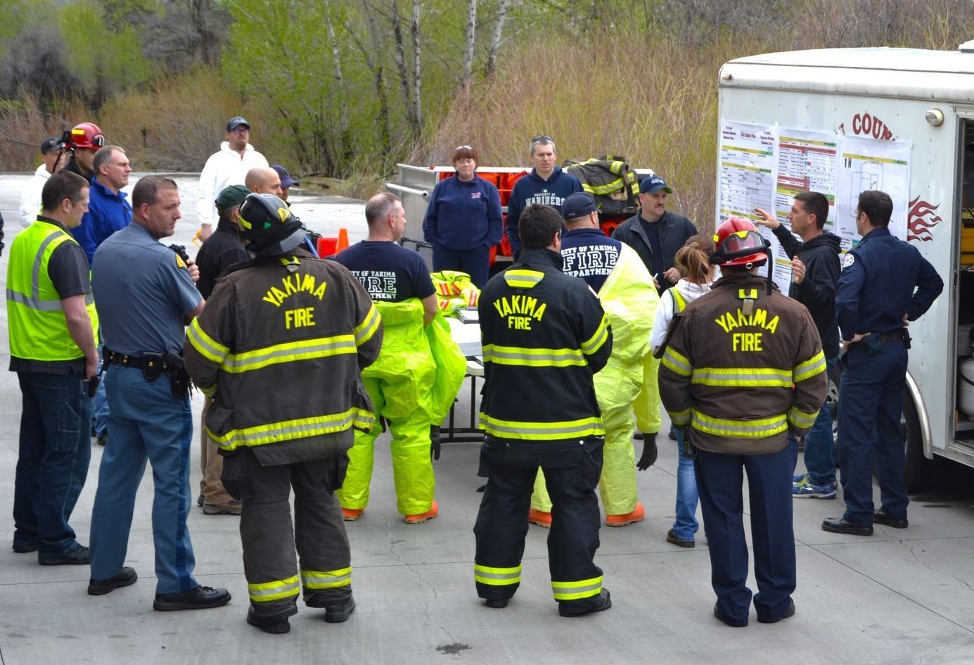 A group of firefighters are standing in a parking lot