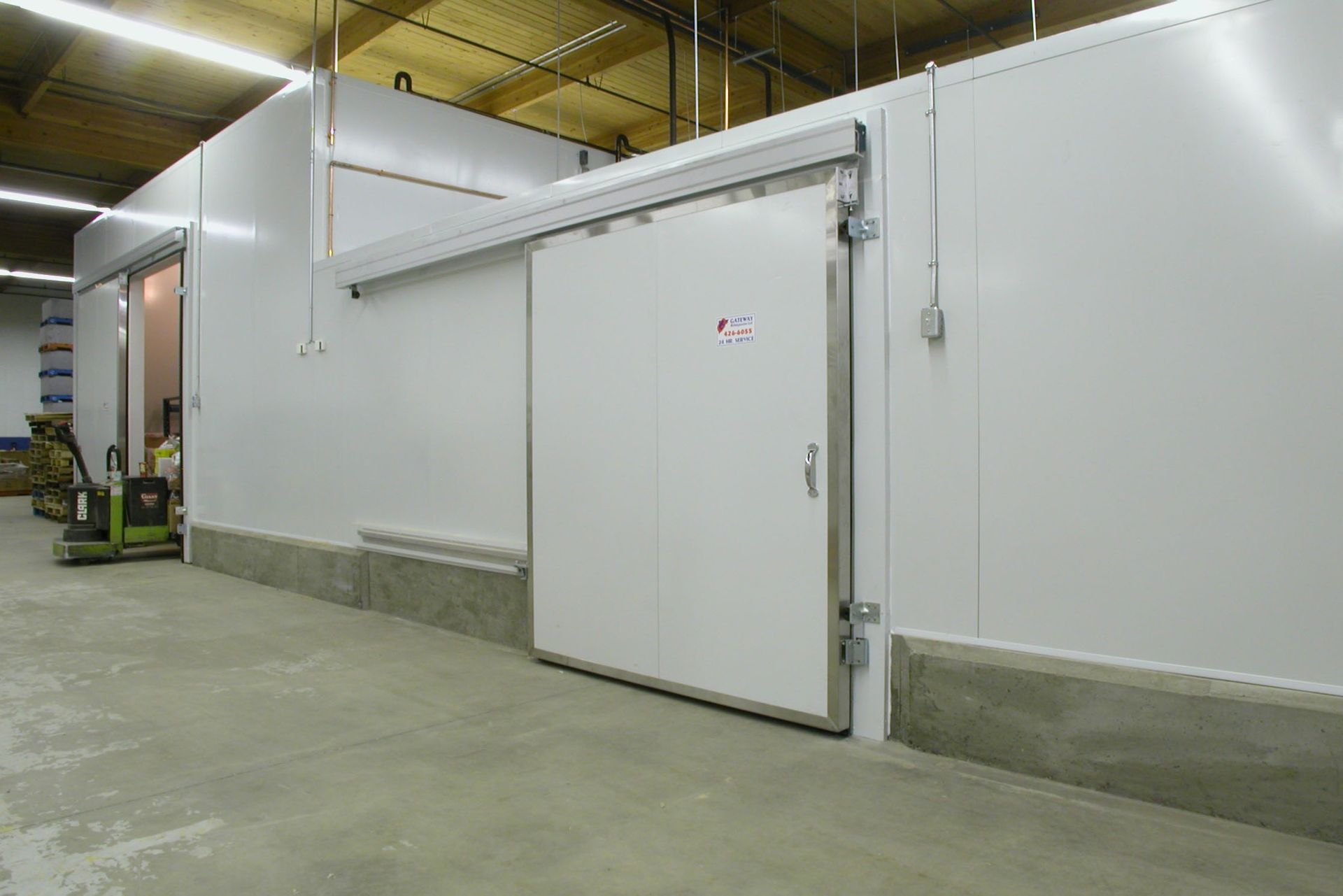 White refrigerated storage room with a large sliding door.
