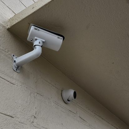 A security camera is mounted on the side of a building.