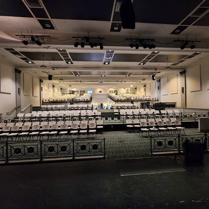 A large auditorium with rows of chairs and a stage