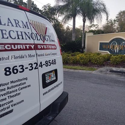 A white van that says alarm technology on the back