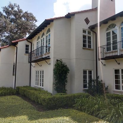 A large white building with many windows and a balcony