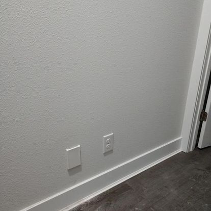 There are two electrical outlets on the wall next to the door.