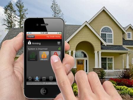 A person is holding a smart phone in front of a house