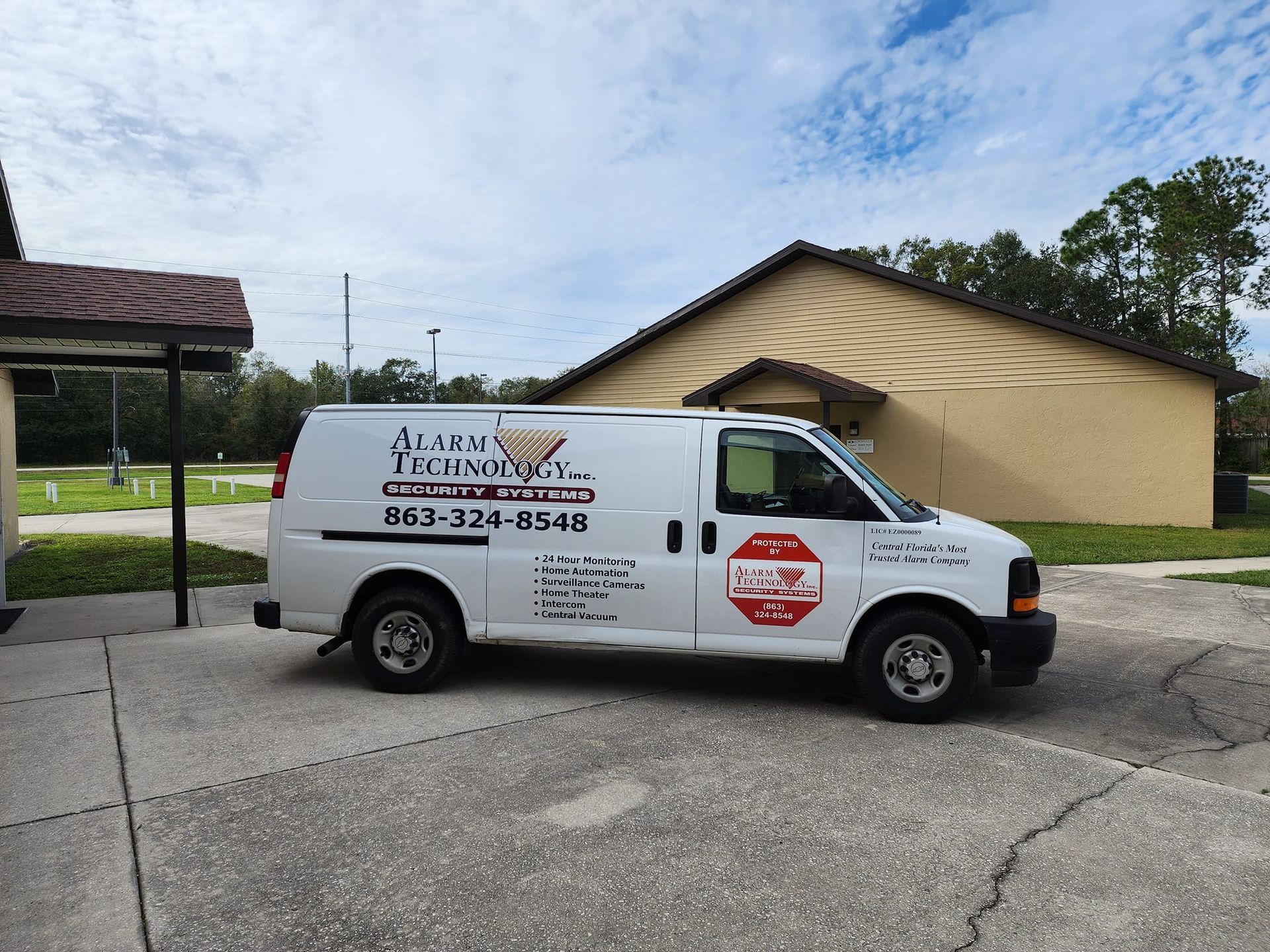 A man and a woman are sitting at a table looking at a security system.