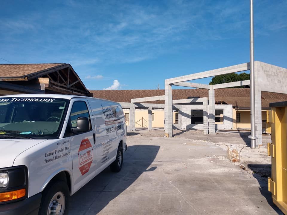 A white van is parked in front of a building under construction