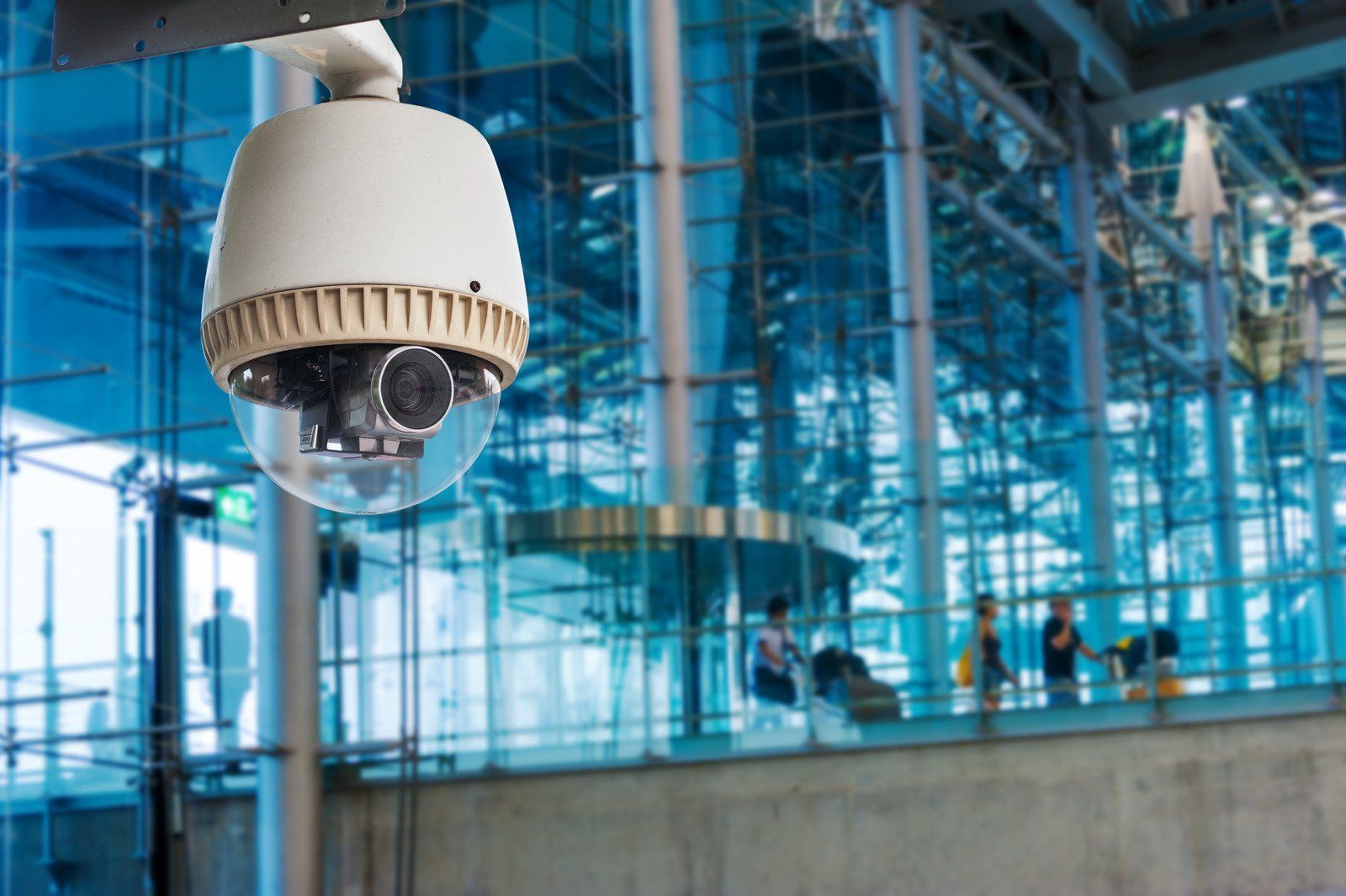 A security camera is hanging from the ceiling of a building.