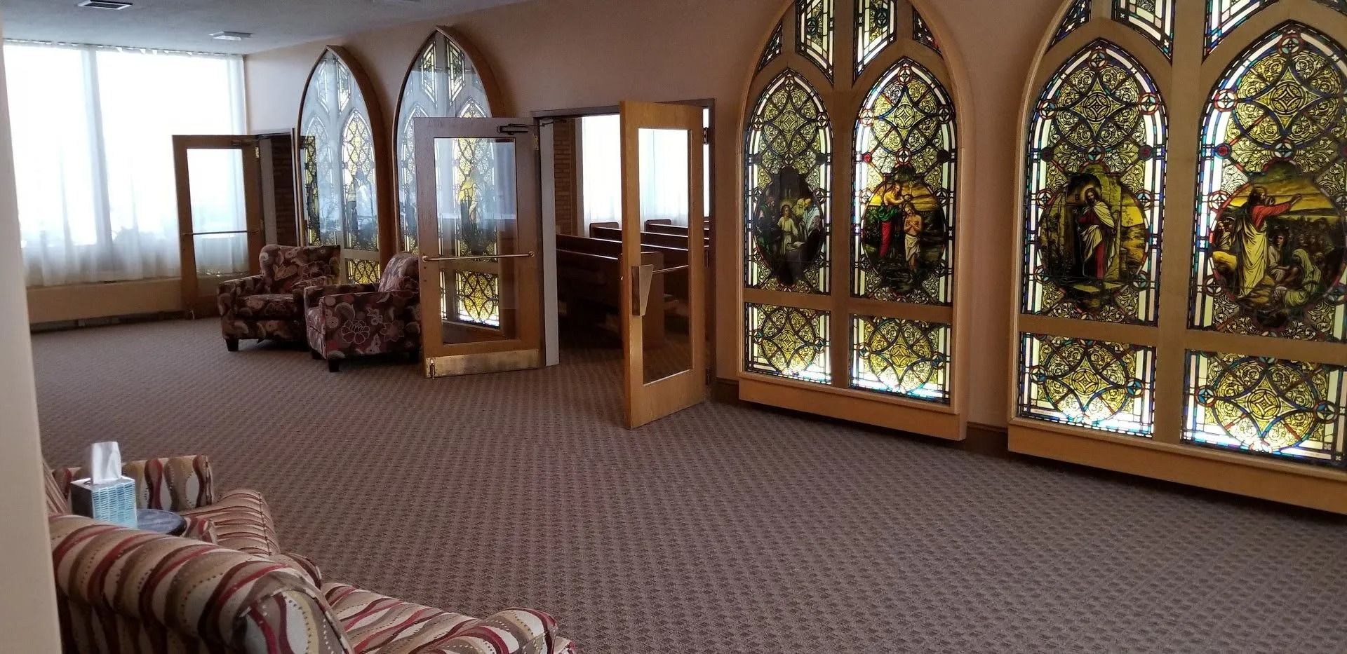 A living room with stained glass windows and a couch.