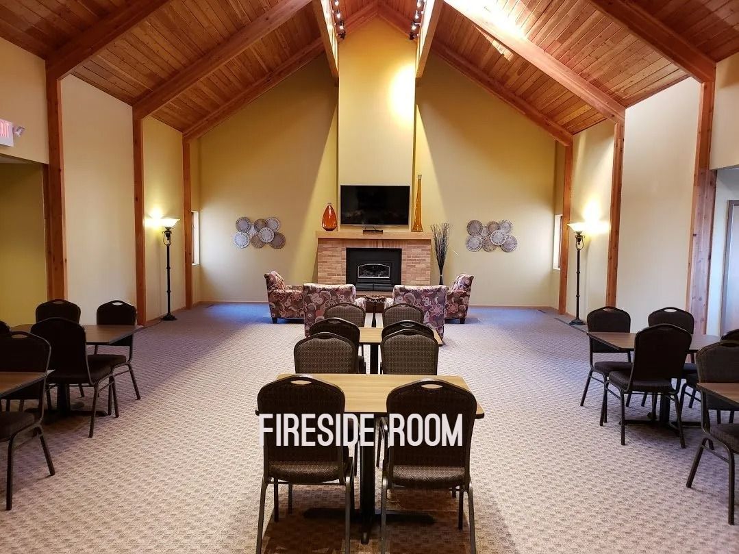 A fireside room with tables and chairs and a fireplace