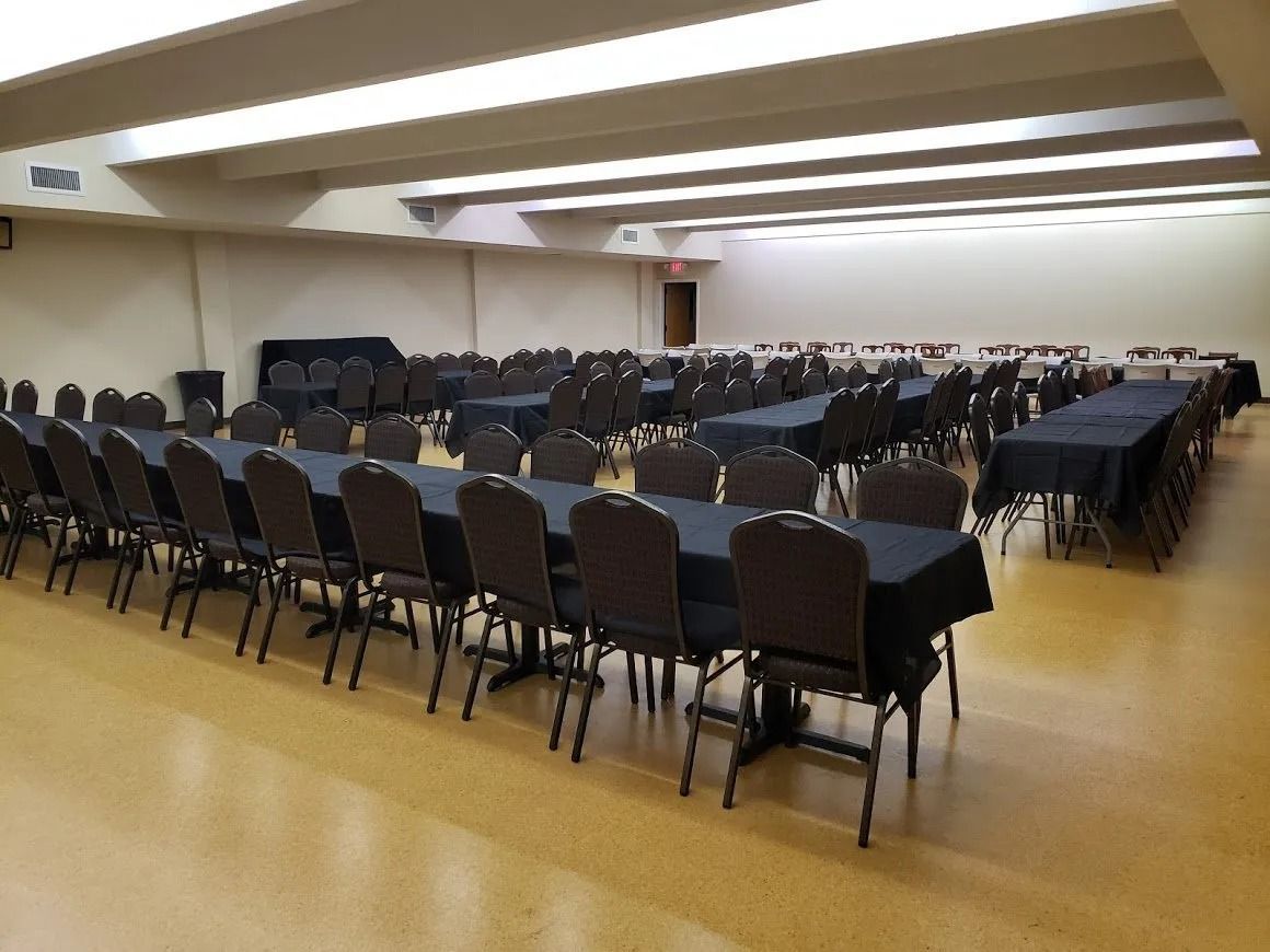 A large room with tables and chairs set up for a banquet.