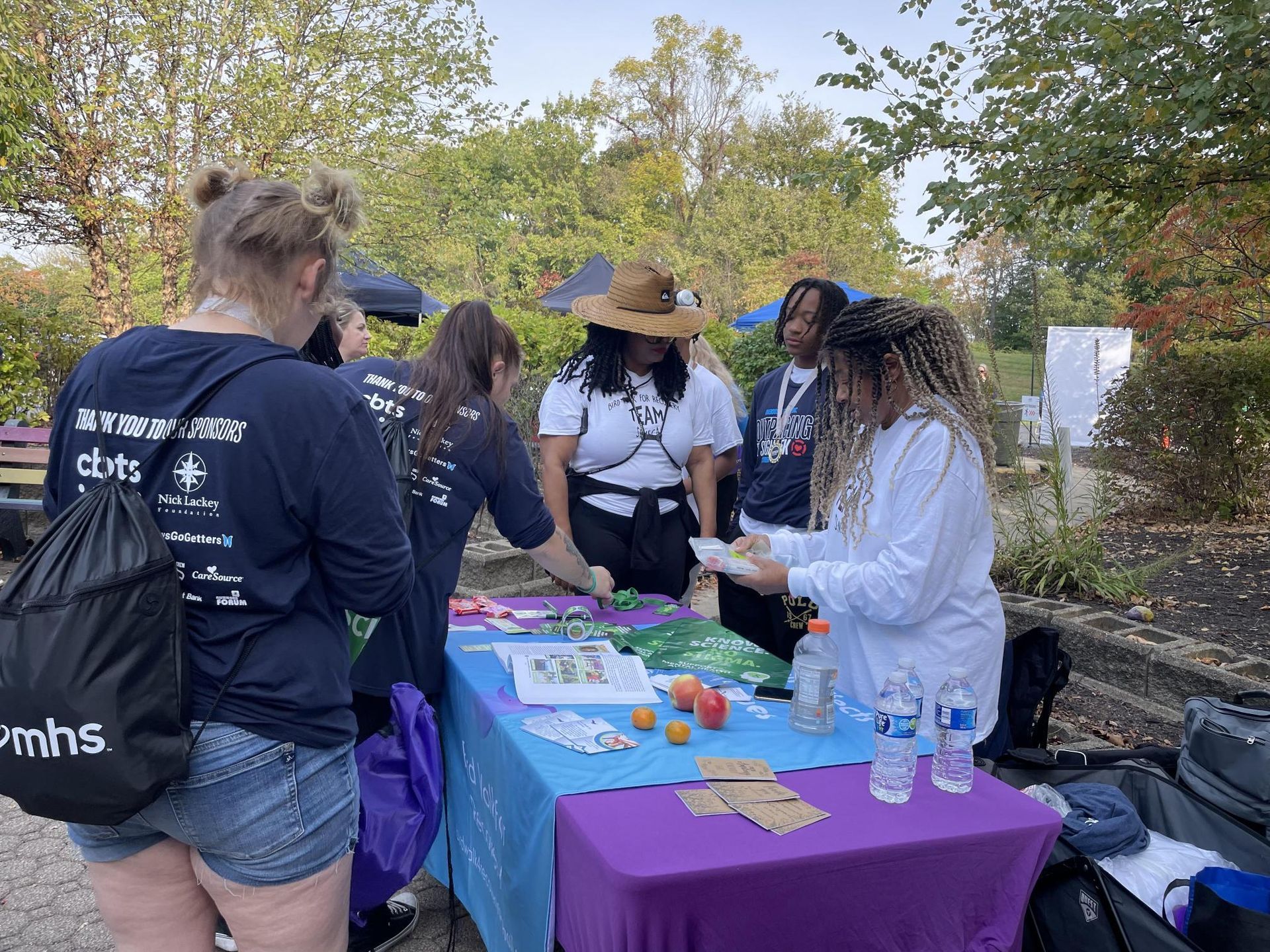 A group of people are standing around a table.