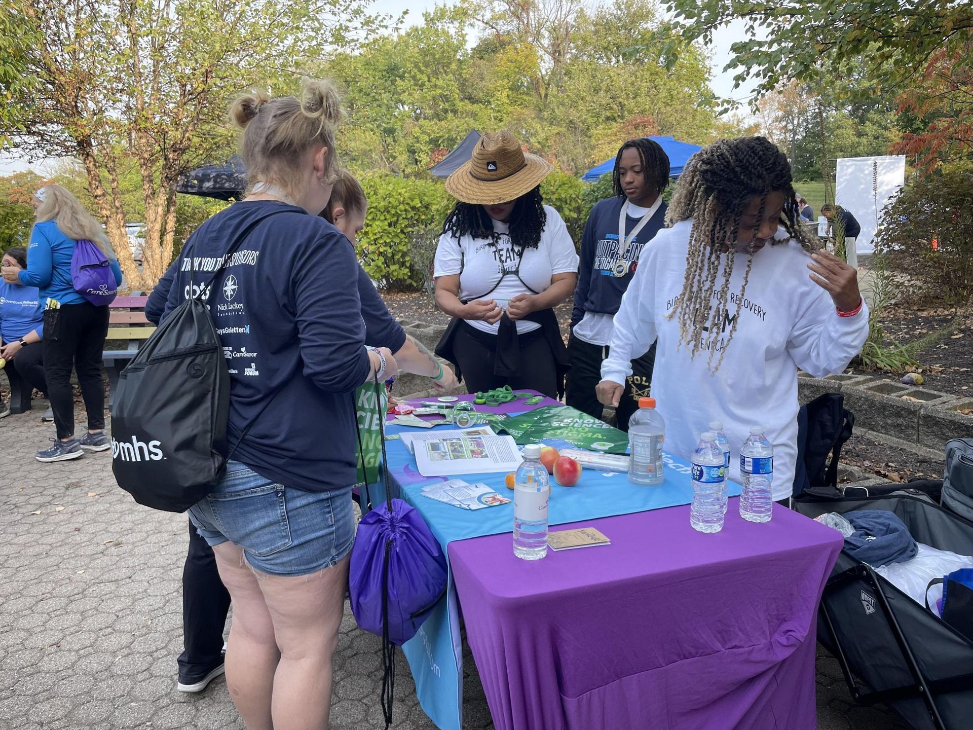 A group of people are standing around a table.