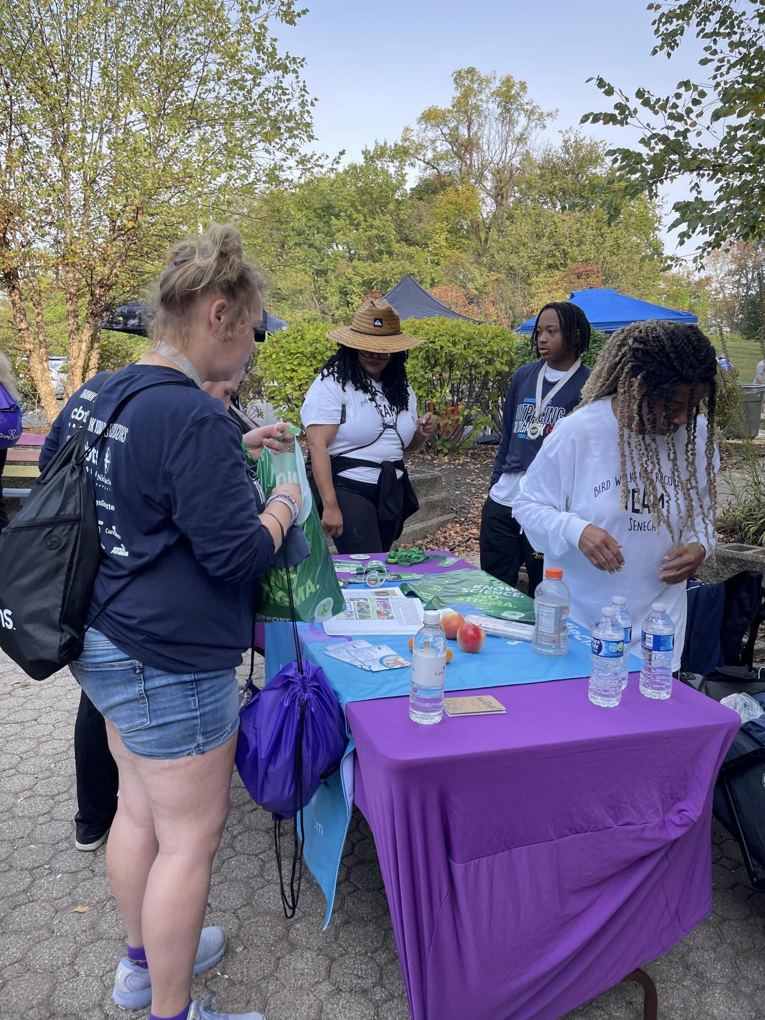 A group of people are standing around a table.