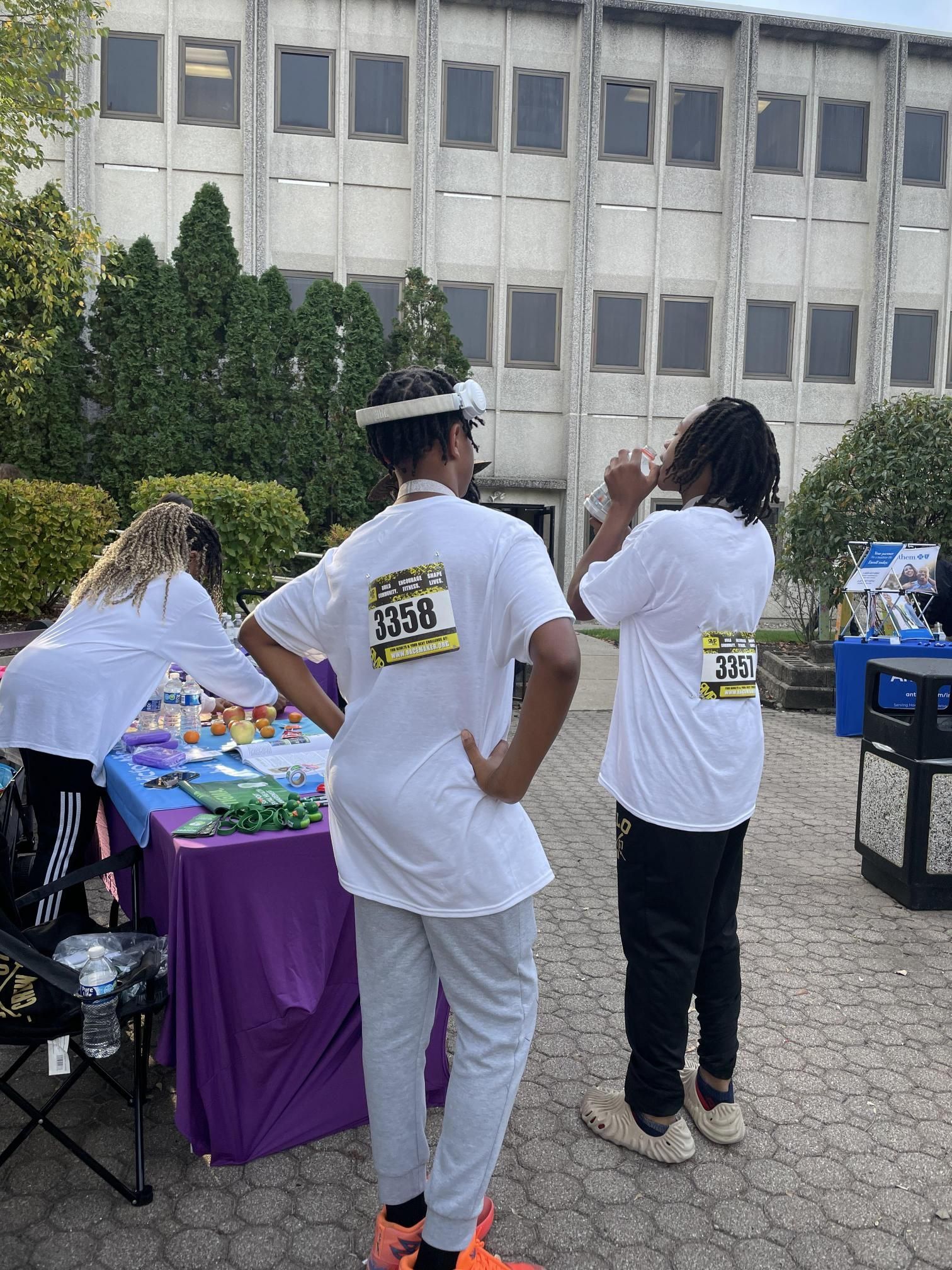 A group of people are standing around a table in front of a building.