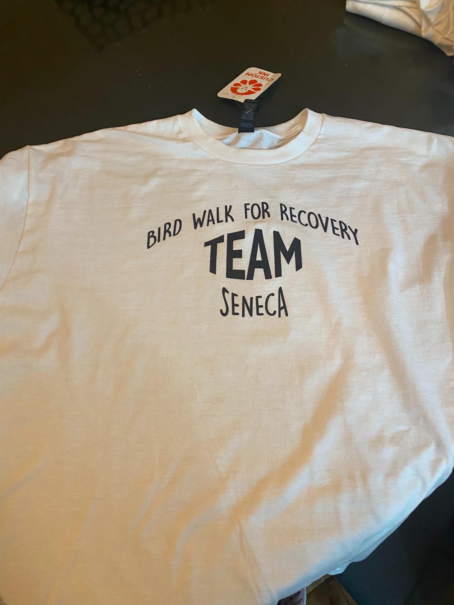 A white shirt that says bird walk for recovery team seneca