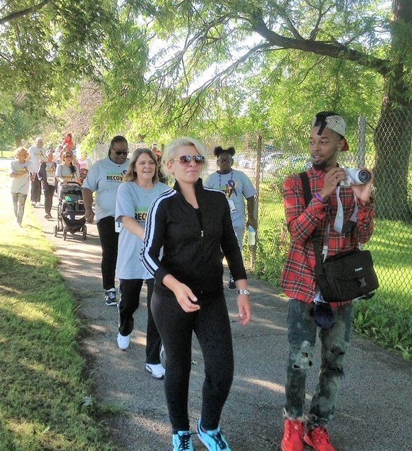 A man is taking a picture of a group of people walking down a path