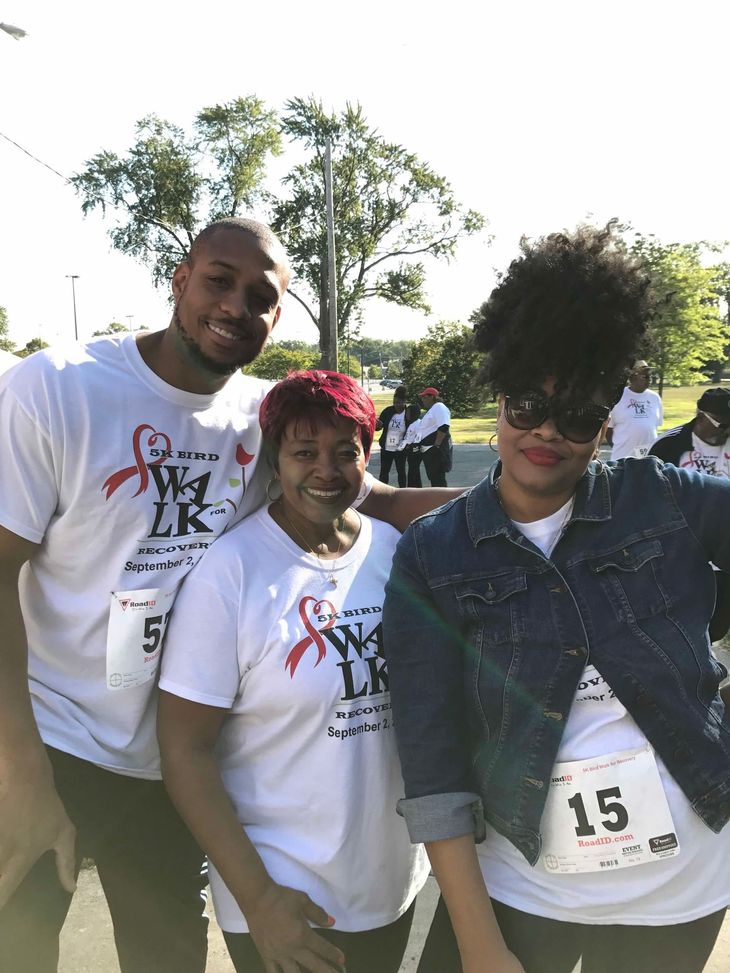 A group of people posing for a picture with one wearing a tag that says 15