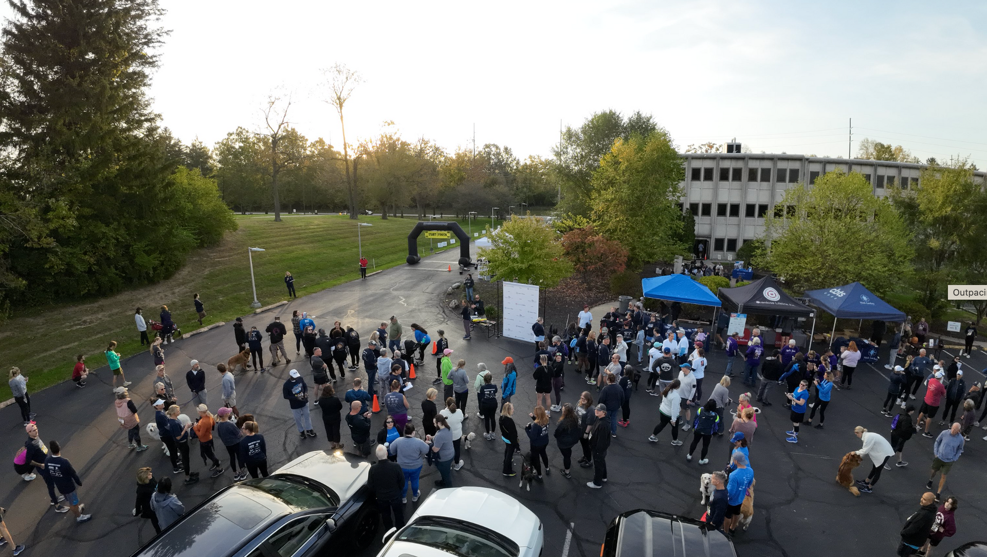 A large group of people are gathered in a parking lot.