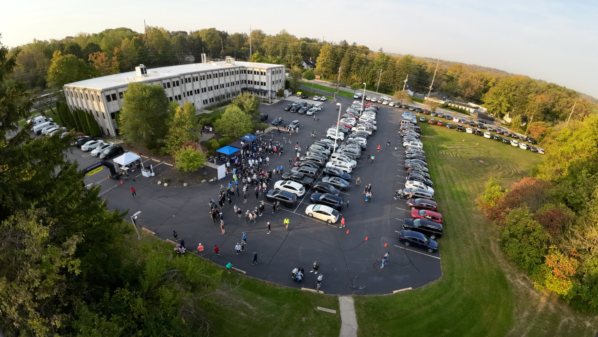 An aerial view of a parking lot filled with cars and people.