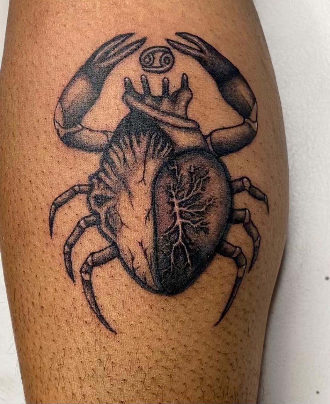 A tattoo of a crab with a heart inside of it