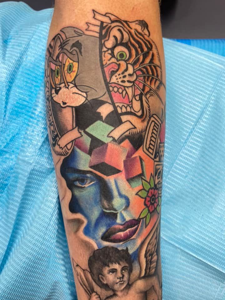 A person has a tattoo of a face and a tiger on their arm.