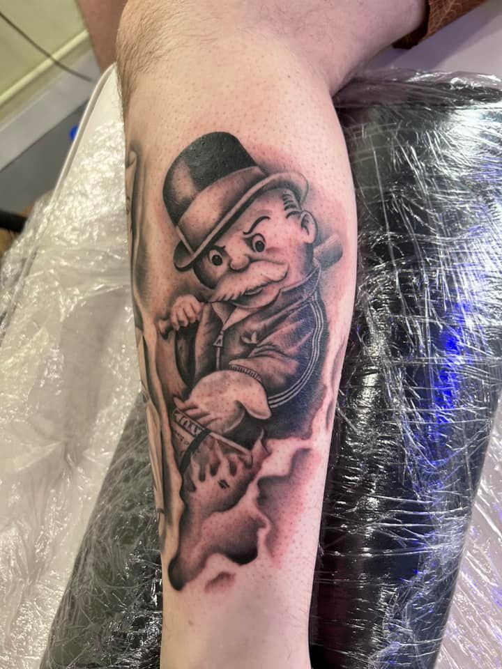 A person has a tattoo of a man in a hat on their leg.